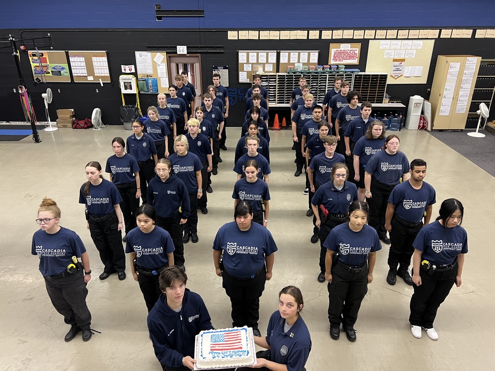 CJ students in formation with a cake
