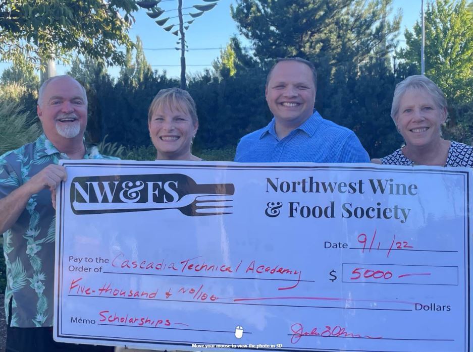 Four people holding a large check