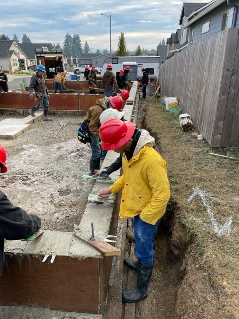 Students using trowels to smooth concrete